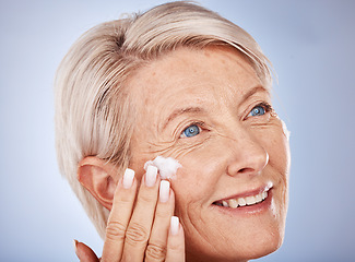 Image showing Skincare, thinking and senior woman with cream for face against a grey studio background. Sunscreen, happy and elderly model with an idea with a facial dermatology product for beauty and self care