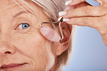 Image showing Mature woman, face and facial roller for smooth, anti aging and lifting treatment for wrinkles and wellness on a grey studio background. Beauty, rolling cosmetology for face massage with rose quarts