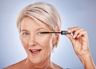 Image showing Makeup, mascara and portrait of a senior woman with a natural, cosmetic and beauty routine in a studio. Cosmetics, beautiful and elderly model with a eyelash product isolated by a gray background.