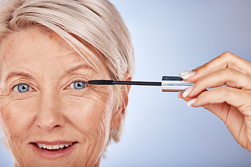 Image showing Portrait, makeup and senior woman mascara for eye, skincare or wellness for natural beauty against blue studio background. Cosmetics, mature lady or elderly female with eyelashes, smile and confident
