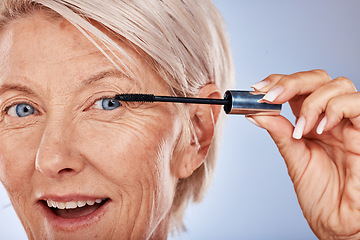 Image showing Makeup, wow and senior woman with mascara for beauty, cosmetics and care for eyelash against a grey studio background. Happy, portrait and face of elderly cosmetic model with a product for a makeover