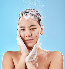 Image showing Shower, shampoo and hair care, woman with soap and clean portrait for grooming and hygiene against blue studio background. Face, hands and wellness with washing hair and beauty with water droplets.