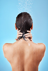 Image showing Back, shower and woman hygiene, wellness and body care for health, skincare and against blue studio background. Clean, female and girl wet, natural beauty and water splash to relax and washing.