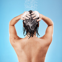 Image showing Shower, hair and shampoo with a woman cleaning using water for haircare in studio on a blue background. Hygiene, water and cleanliness with a female washing for treatment or hydration in the bathroom