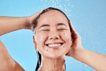 Image showing Woman, shower and smile for skincare hygiene, wash or cleanse against a blue studio background. Happy female face smiling in satisfaction for clean wellness, cosmetics or healthy hair care treatment