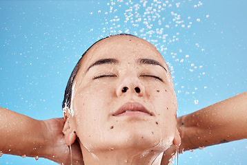 Image showing Woman, shower and skincare hydration for beauty, hygiene or cleanse against a blue studio background. Female relaxing for calm cleansing in hygienic wellness, satisfaction or body care treatment