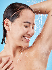 Image showing Skincare, cleaning and woman in shower in studio isolated on a blue background. Water splash, hygiene and healthy female model from Canada bathing and washing for beauty, body care and wellness.