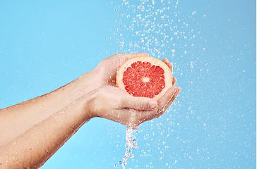 Image showing Grapefruit in hands, water splash and studio background for healthy, vegan and wellness food on advertising, marketing or promotion mockup. Detox, vitamin c and juice fruit benefits in clean skincare