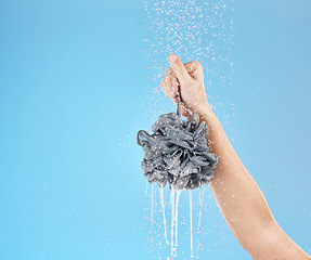 Image showing Shower, loofah and hand of woman in studio on blue background mock up. Skincare, water splash and female model holding sponge for showering, washing or bathing for hygiene, health or wellness mockup