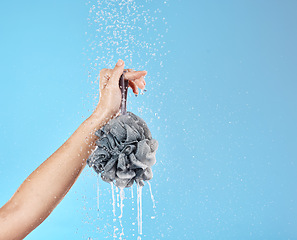 Image showing Shower, water and hands with a loofah for luxury wellness, cleaning and grooming against blue studio background. Health, cosmetic and woman with product for body care and treatment with mockup space