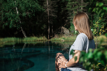 Image showing Woman resting at mountain lake in summer