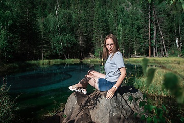 Image showing Woman resting at mountain lake in summer