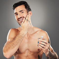 Image showing Man, aftershave and skincare portrait for face and beard on a grey studio background for wellness and beauty. Skin care, cologne and man apply product to face for grooming, clean facial hair