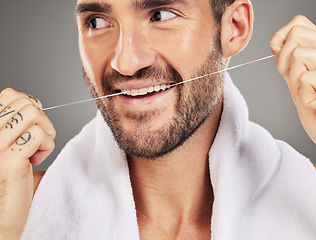 Image showing Man, floss and teeth. dental health and hygiene for mouth wellness, advertising and cleaning product against a grey studio background. Male model, clean and tooth healthcare, healthy and flossing