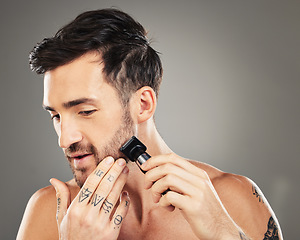 Image showing Shave, razor and man cut beard hair for grooming and hygiene or health and wellness on a grey studio background. Epilation, shaving and beauty with electric razor and facial routine for male