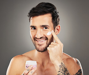 Image showing Skincare, wellness and man with facial cream isolated on gray background in studio. Beauty, grooming and male apply lotion, beauty product and skincare products on face for body care and healthy skin