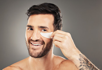 Image showing Man, eye patch and product for skincare, beauty and health with a smile for cosmetic, collagen and dermatology. Male, happy and face portrait with young model advertising healthy skin and wellness