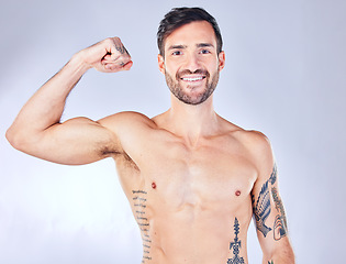 Image showing Man, fitness and bicep muscle flex on gray studio background for training, exercise and workout success. Portrait, happy smile or muscular model and athlete showing bodybuilding arm growth or success