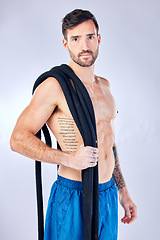 Image showing Fitness, battle ropes and health with a man athlete in studio on a gray background for exercise or training. Muscle, strong and heavy ropes with a male bodybuilder posing with equipment for a workout
