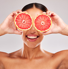 Image showing Grapefruit, skincare and wellness of a woman holding fruit, skincare and vitamin c for face glow. Model with fruits for health, cosmetic eye treatment and healthy diet nutrition food with beauty