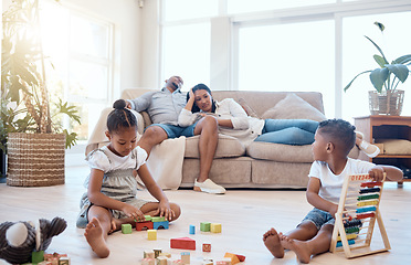 Image showing Tired parents on couch, children and playing with toys on weekend to relax, for bonding and sleepy in lounge. Family, mother and father with brother, sister and play educational games and exhausted.