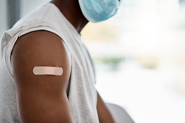 Image showing Closeup, bandage and covid vaccine for black man with mask for healthcare, wellness or safety. Man arm, plaster and vaccination for covid 19 in hospital, clinic or office for health, medicine or care