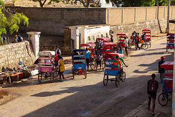 Image showing Traditional rickshaw bicycle with Malagasy people on the street of Toliara, one of the ways to earn money. Everyday life on the street of Madagascar.