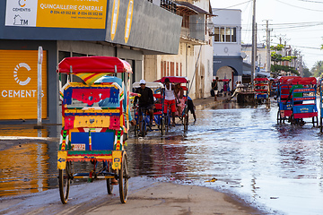 Image showing Traditional rickshaw bicycle with Malagasy people on the street of Toliara, one of the ways to earn money. Everyday life on the street of Madagascar.