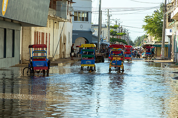 Image showing Traditional rickshaw bicycle with Malagasy people on the street of Toliara, one of the ways to earn money. Everyday life on the street of Madagascar.