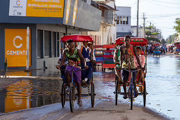 Image showing Traditional rickshaw bicycle with Malagasy people on the street of Toliara, one of the ways to earn money. Everyday life on the street of Madagascar.