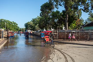 Image showing Traditional rickshaw bicycle with Malagasy people on the street of Toliara, one of the ways to earn money. Everyday life on the street of Madagascar.