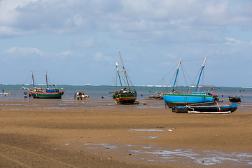 Image showing Fishing boat stranded on the dry port during low tide with Malagasy people around.