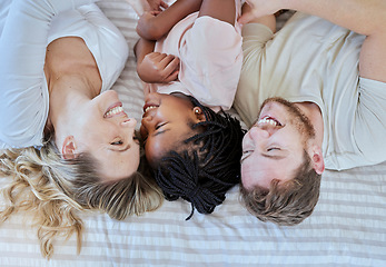 Image showing Family, love and happy together with care in family home, smile in overhead with adoption or foster care. Happy family, interracial and happiness with mother, father and child lying on bed bonding.