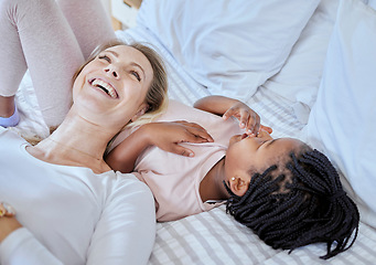 Image showing Mother, girl and adoption child in bedroom, family home and house for fun, bonding or quality time with love, care and happiness together. Black kid relax with foster care mom, diversity and laughing