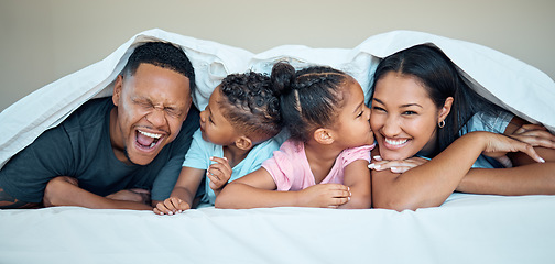 Image showing Black family, bed together and happy under blanket in home with love, care and bonding with kiss on cheek. Black woman, man and kids in bedroom in house for happy family moment, time or relax in home