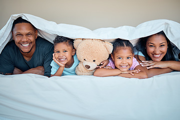 Image showing Family, bed and portrait of parents with children under blanket bonding, smiling and enjoying morning. Affection, black family and mom and dad with kids in bedroom laying together with teddy bear