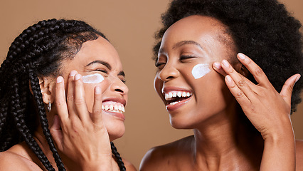 Image showing Black woman, cream and skincare with friends support, love and beauty together in studio for cosmetics, makeup cleaning and facial. Excited, diversity model with sunscreen or essential oil on face