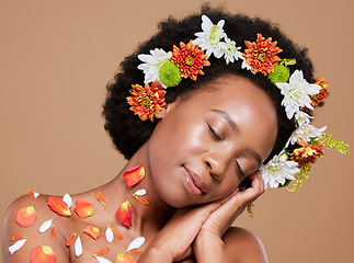 Image showing Flower, crown and black woman relax in studio for beauty, skincare and plant product on brown background. Nature, flowers and woman, skin and wellness model happy, calm and organic, luxury and facial
