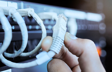 Image showing Hand on network cable in server room or data center for maintenance on server machine. Technology, connection and wires in datacenter, information storage and hands of engineer or technician closeup.