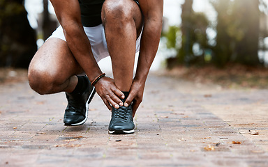 Image showing Sports injury, ankle pain and fitness accident of a man doing massage on feet for physical therapy after exercise, workout and training. Athlete runner outdoor for orthopedic health problem on ground