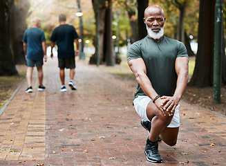 Image showing Senior african man, stretching and park with focus for fitness, wellness and exercise on ground. Elderly black man, lunge and leg workout, training or muscle development in street for body health