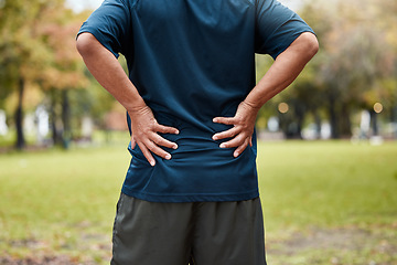 Image showing Exercise, fitness and back pain of man at park after workout. Break, healthcare or mature male runner with back injury, muscle pain and inflammation after exercising, running or training in nature