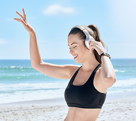 Image showing Headphones, beach and woman dance after workout, training or exercise. Freedom, energy and happy fitness female streaming audio, podcast or radio music at sandy seashore or ocean coast outdoors.