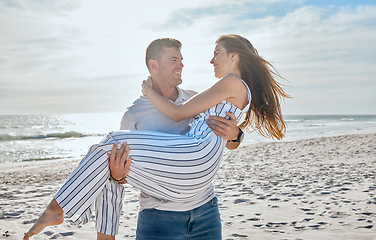 Image showing Couple, love and carrying at beach, holiday and freedom on anniversary, romance and travel together in Hawaii. Man, woman and happy vacation, smile and support in marriage relationship at the ocean
