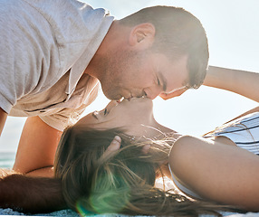 Image showing Love, romance and couple kiss at beach on summer holiday, vacation and weekend together. Relationship, travel and young man and woman kissing laying on sand by ocean, seaside and nature to relax