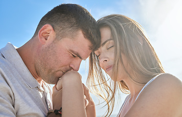 Image showing Love, hand and couple kiss at a beach, sharing intimate moment of romance at sunrise against blue sky background. Travel, freedom and man with woman embrace, care and relax in nature together mockup