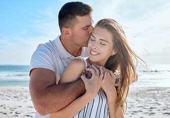 Image showing Love, summer and couple hug at the beach enjoying honeymoon, vacation and holiday together. Travel, nature and man and woman embrace, kiss and hugging by ocean for romance, happiness and affection