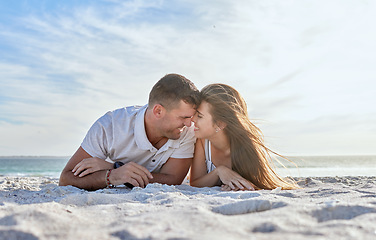 Image showing Love, beach and couple laying in sand, happy woman with man on a summer holiday at ocean. Romance, nature and sun, a happy couple from Australia by the sea, sunset and romantic vacation time together