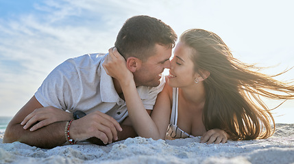 Image showing Love, kiss and couple at the beach for a date, vacation or relax with smile on the sand in summer. Freedom, travel and man and woman with affection, care and peace on a holiday by the sea together