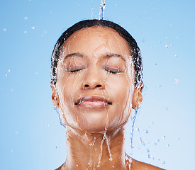 Image showing Woman, shower and water in facial hydration for fresh clean hygiene against blue studio background. Female in healthcare beauty wash for skincare, cleanse and wellness or natural cleansing treatment
